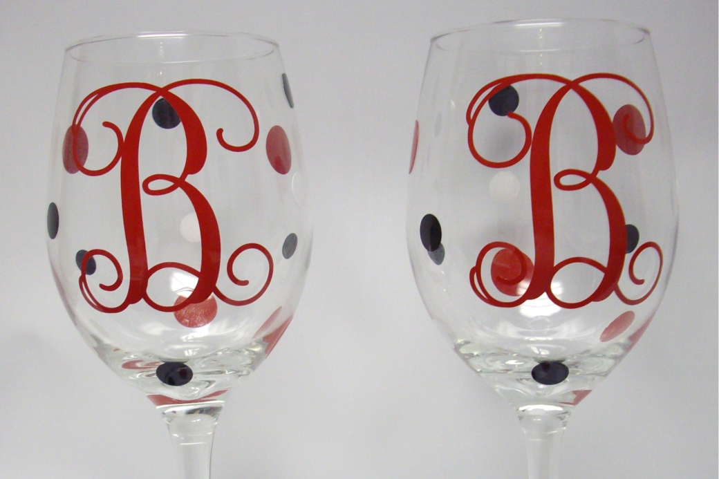 Two custom vinyl wine glasses with white, red, and black decals.